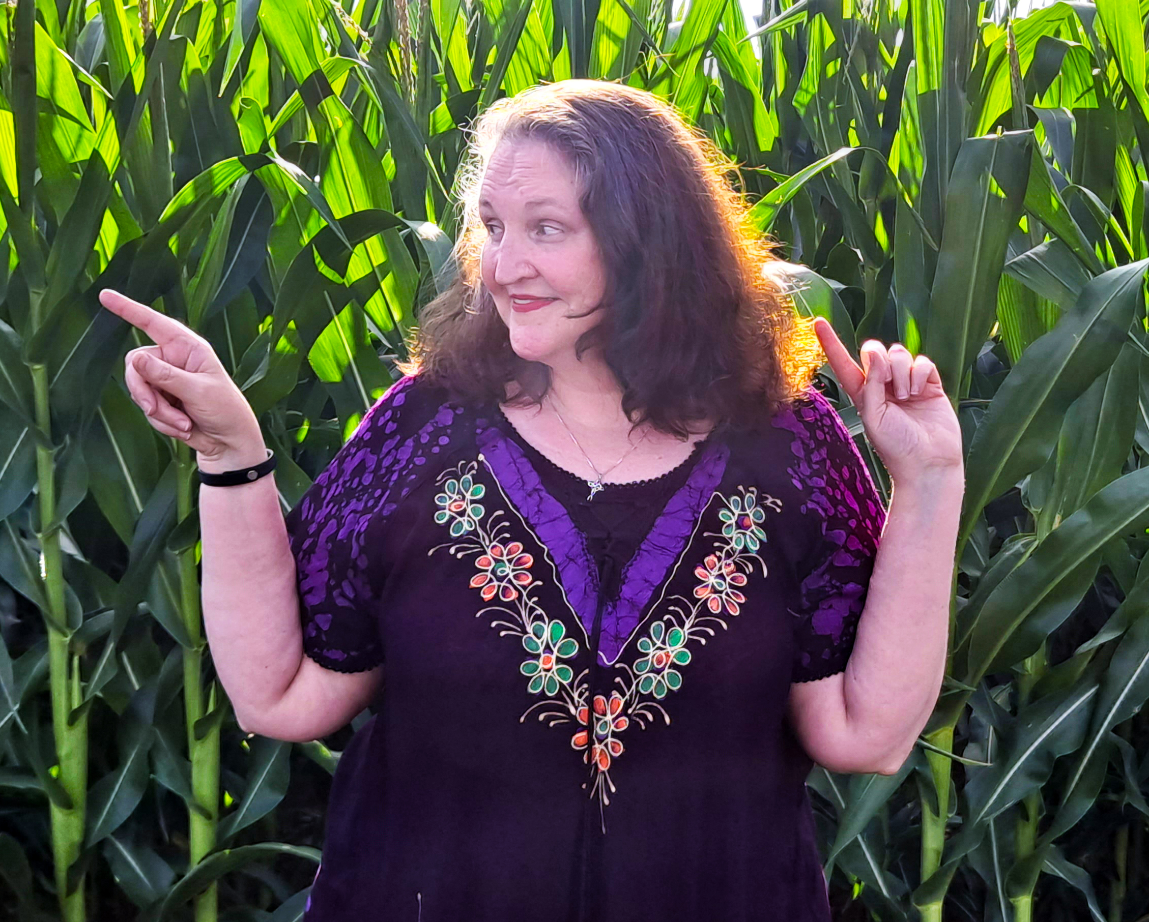 carma pointing left in front of corn